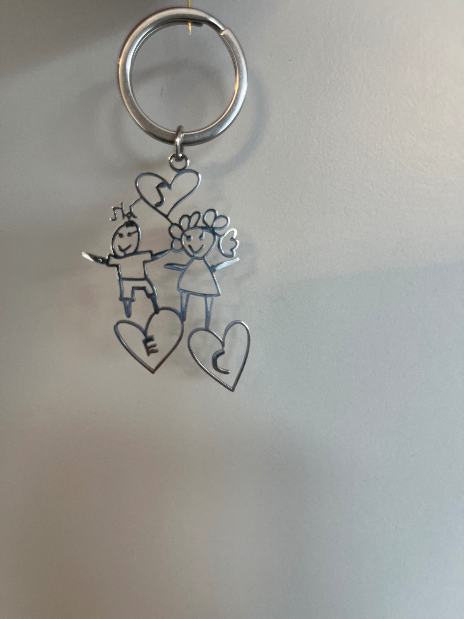 Finished keyring made from the drawing of two people and hearts